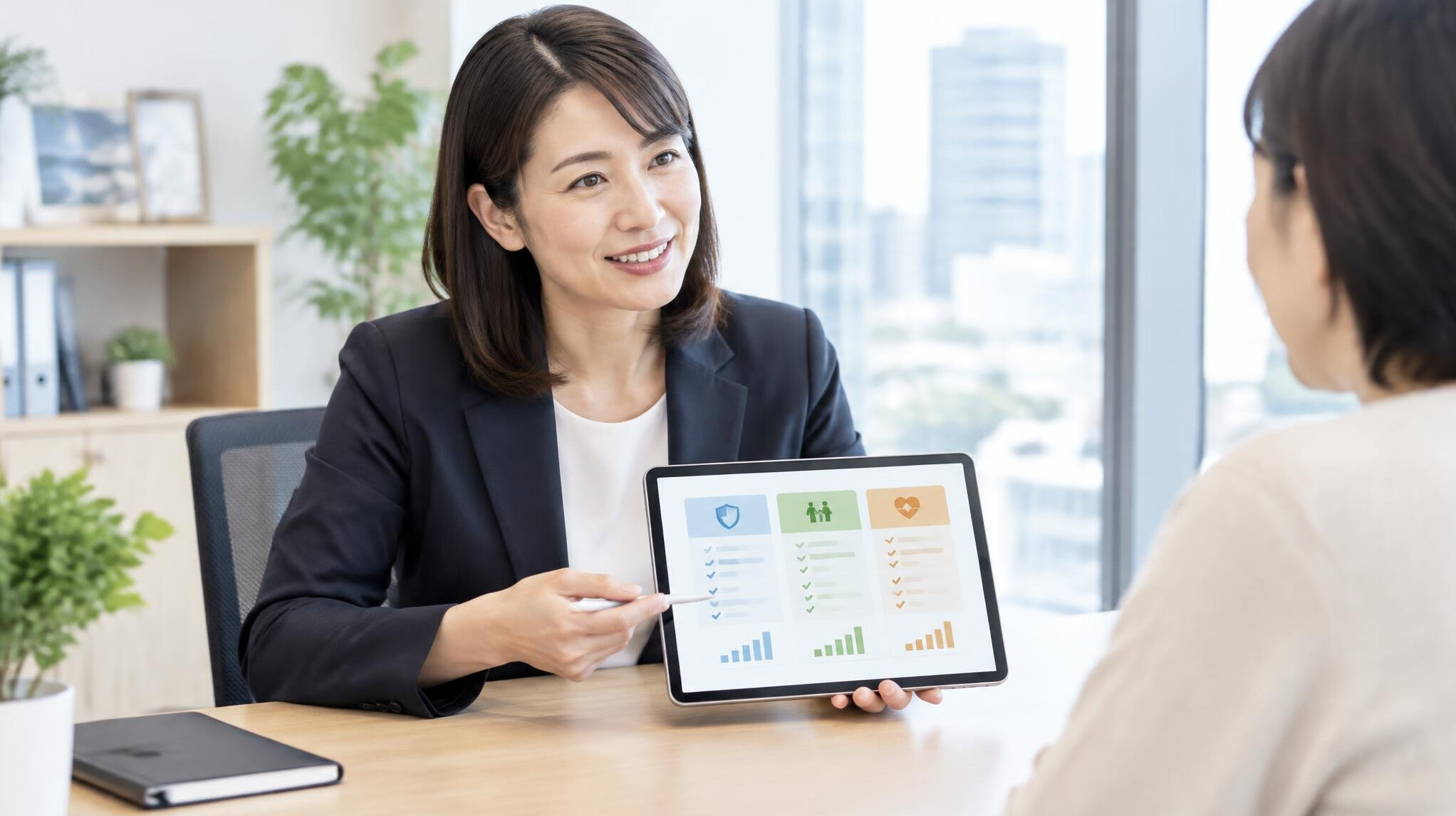 Japanese financial advisor presenting insurance plans on a tablet to a client